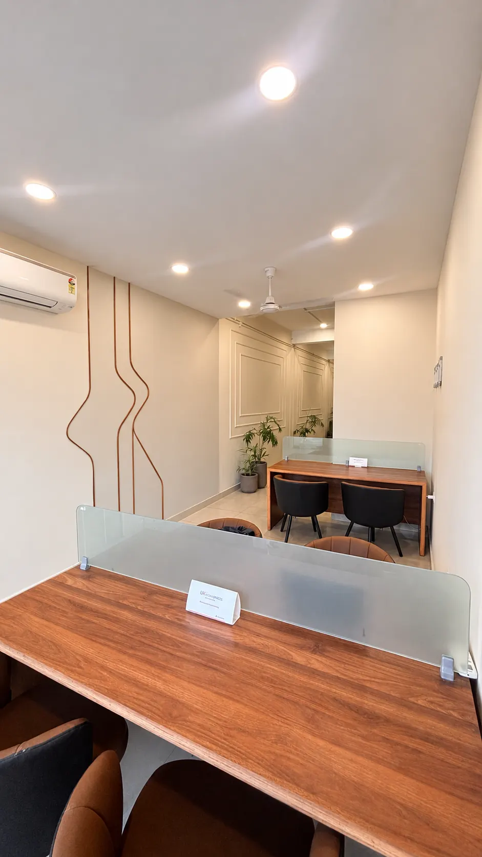 Coworking hall at UK Workspaces with copper wall inlay, recessed lighting and shared desks