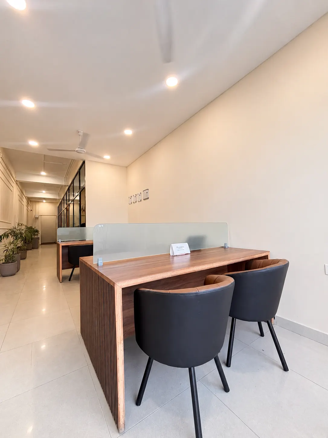 Coworking desks with frosted glass dividers at UK Workspaces Dehradun